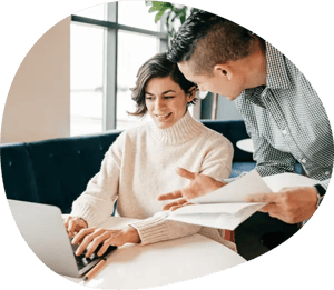 a woman and a man are working with a computer