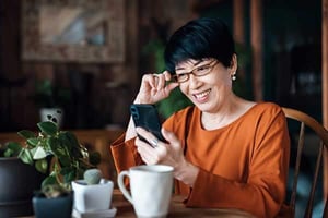 a person smiling while holding a phone a person smiling while holding a phone