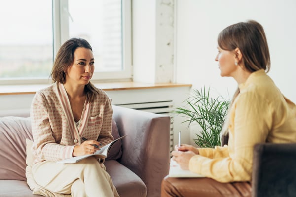 Two women speaking privately in an office