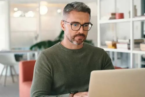 Person wearing glasses working on computer.