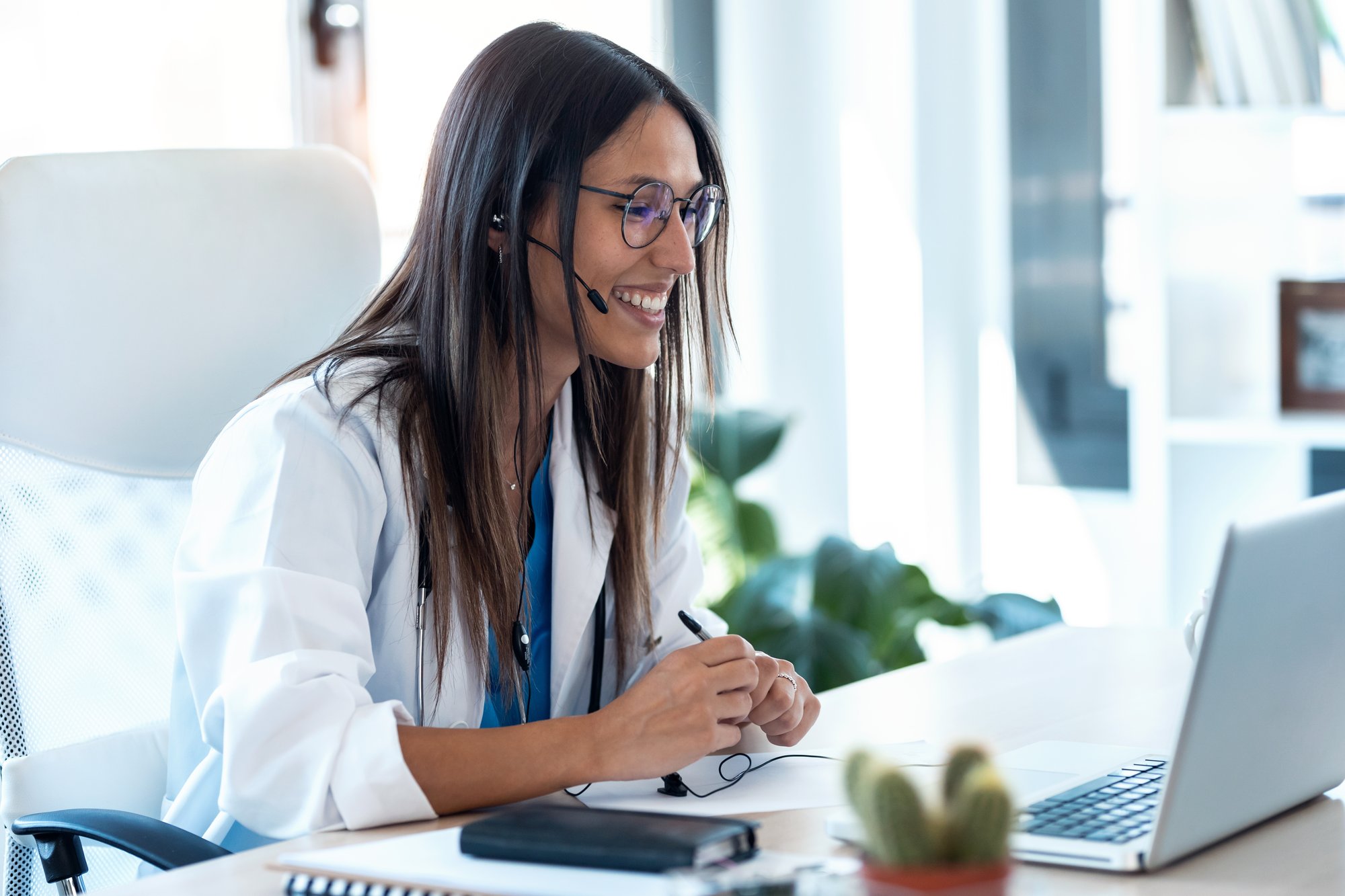 A health care professional looking into a laptop computer.
