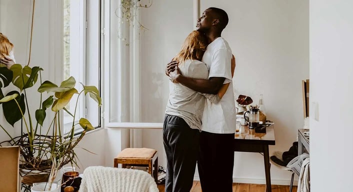 A man and woman embracing in a living room