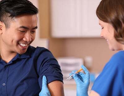 A man receiving an injection from a nurse