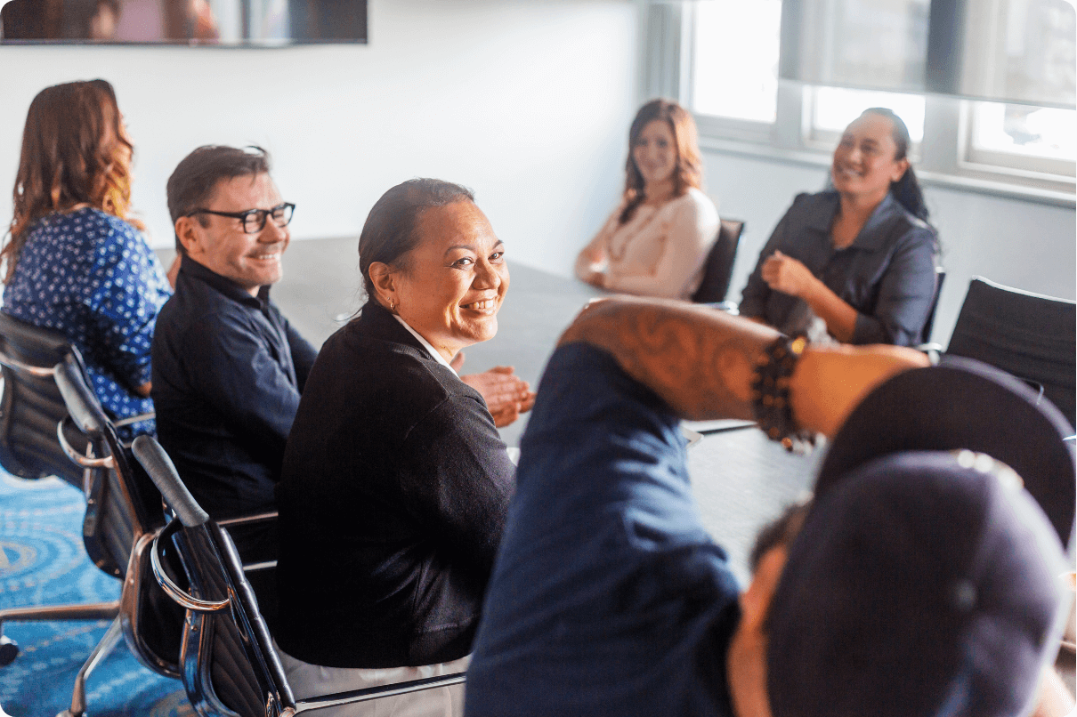 A group of individuals sit around a table at work, share ideas and work together collectively