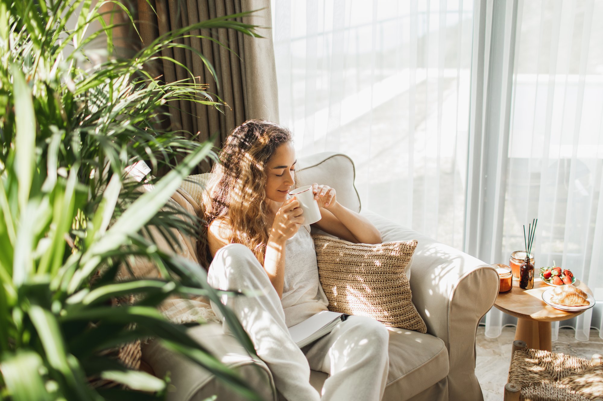 Woman sitting on sofa drinking coffee