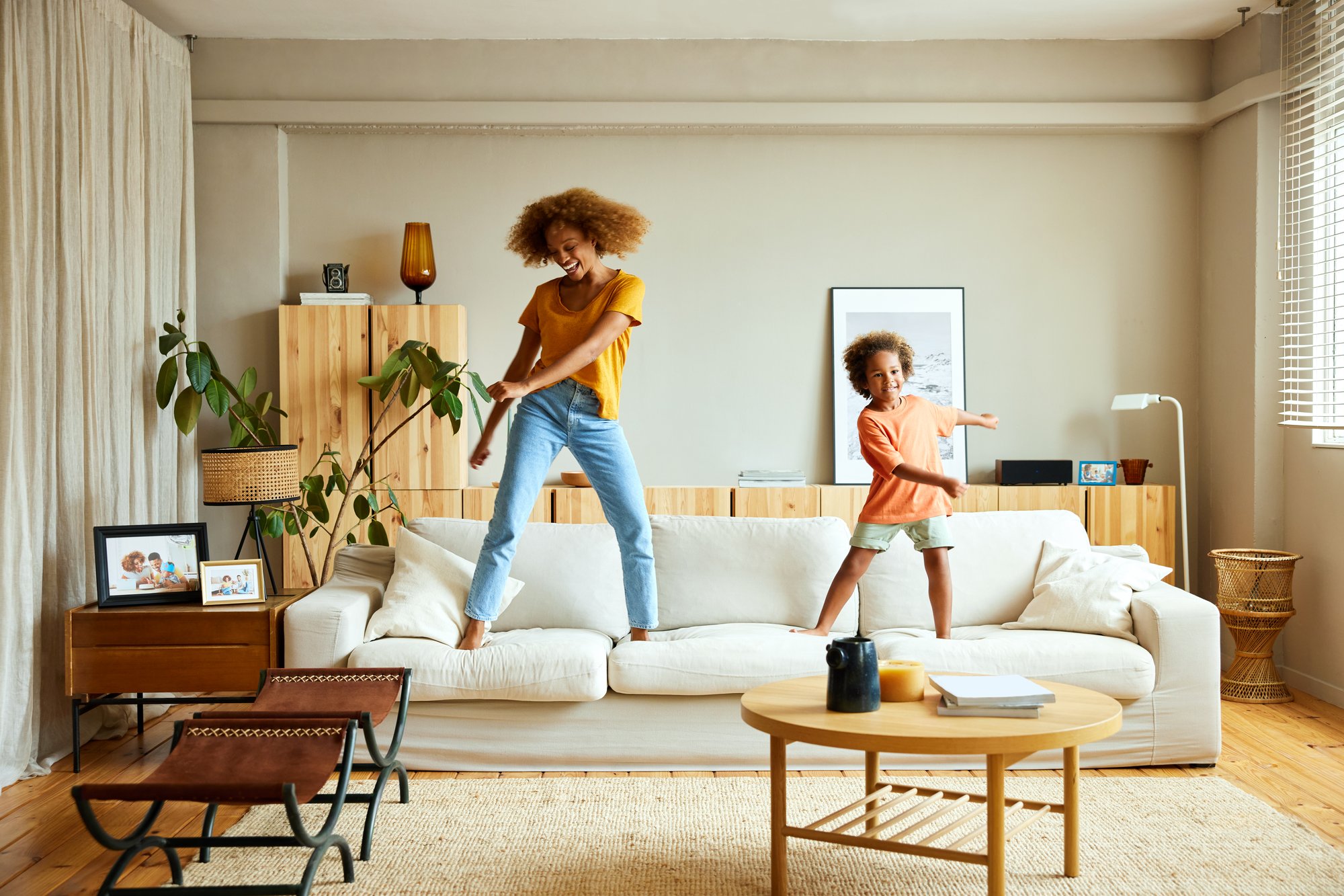 Women and child jumping on sofa