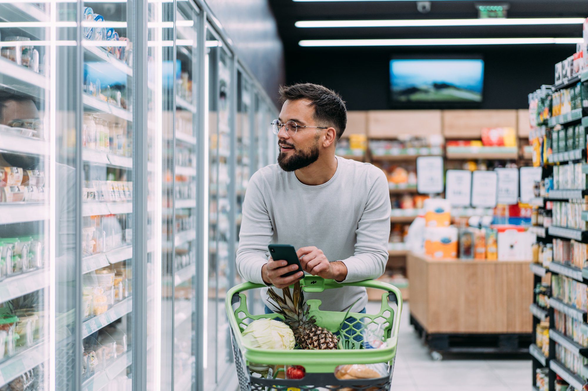 Man grocery shopping with a cart