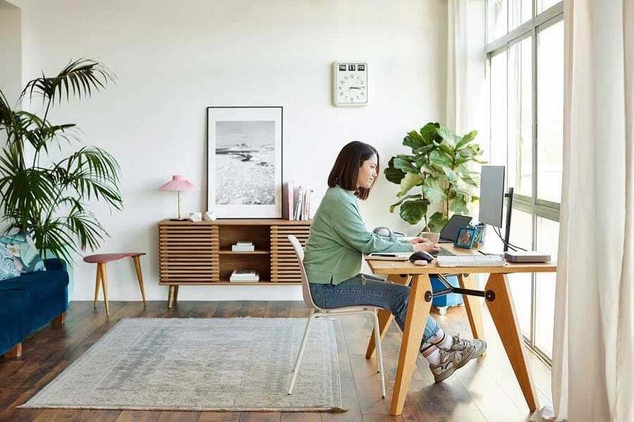 a woman sitting at a desk working on a laptop