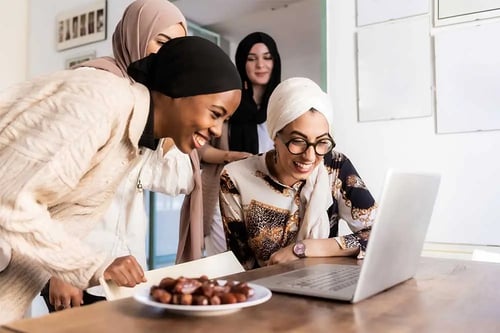 a group of people looking at a laptop