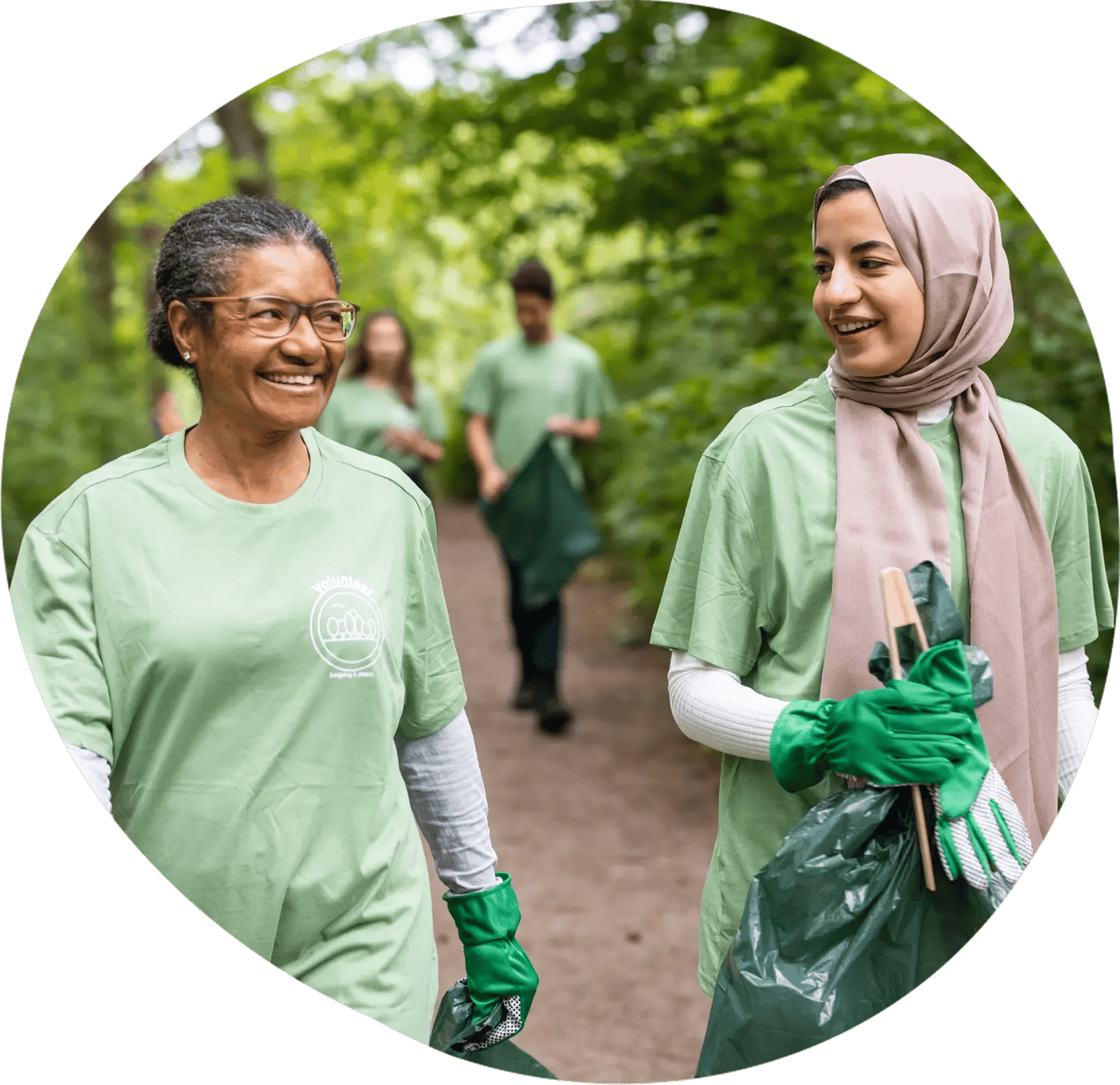 Women volunteering outside picking up garbage in the forest