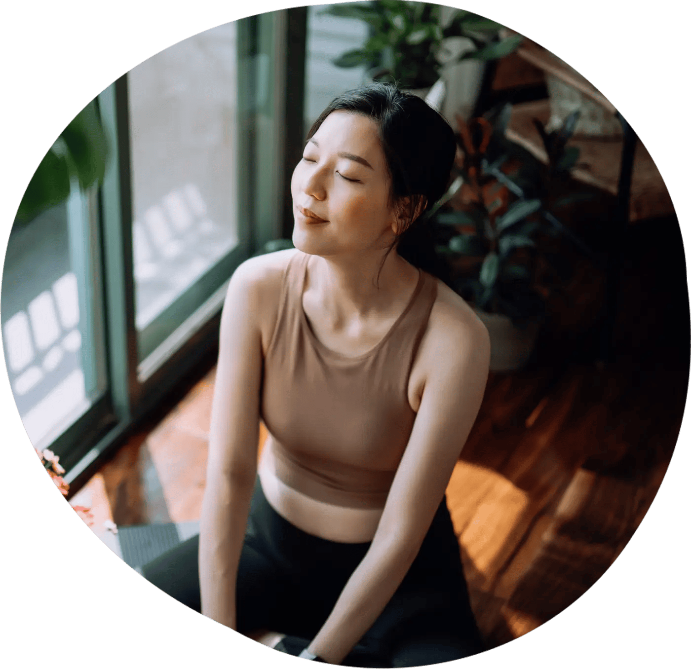 Asian woman sitting on the floor of her home after exercising