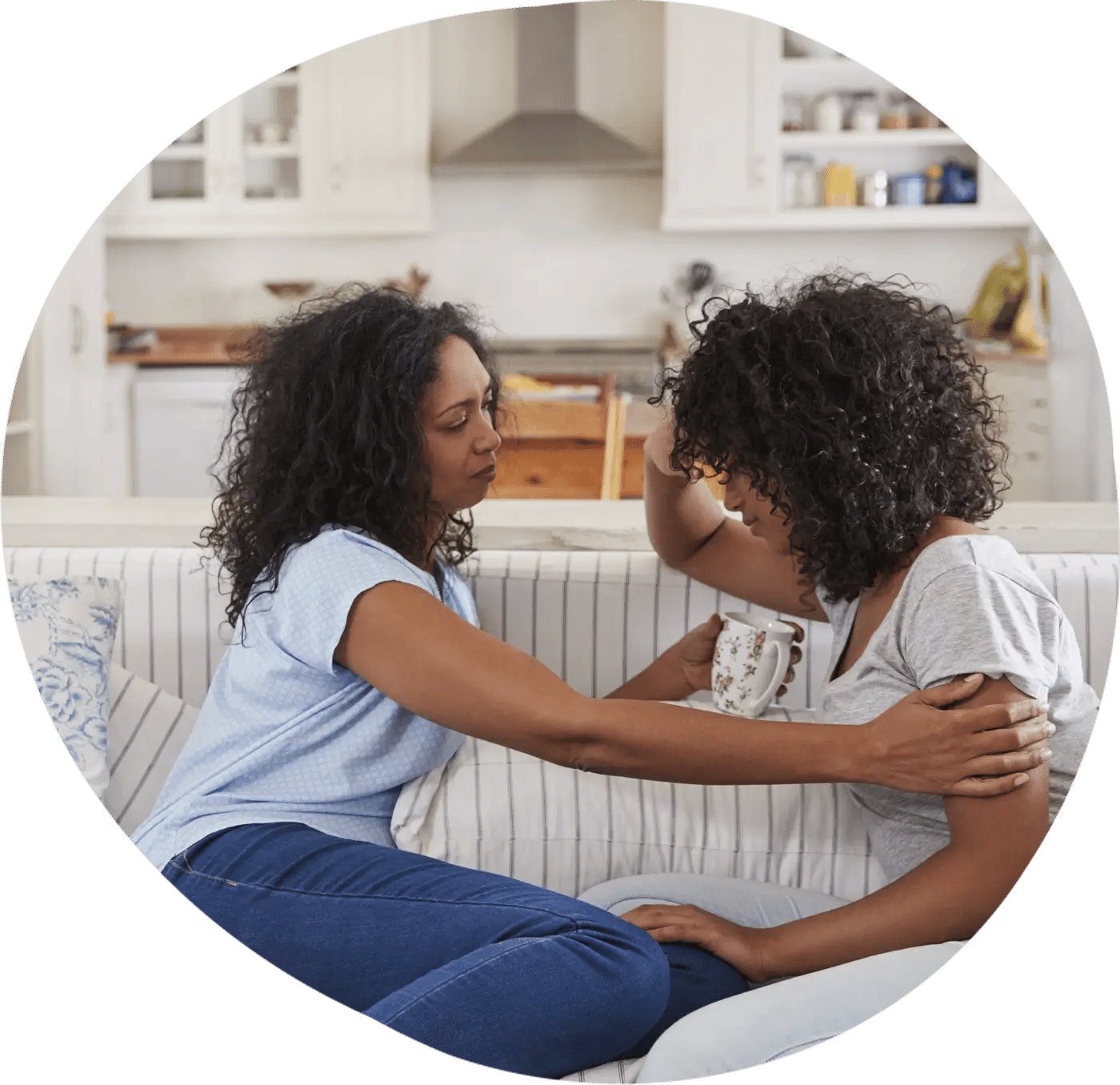 Mother and daughter sitting on the couch talking