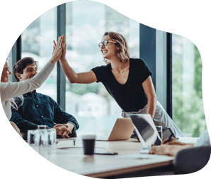 A group of diverse people joyfully high-fiving each other in a bright meeting room. 