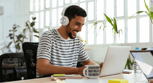 man smiling working on his laptop