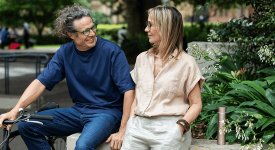 Mature man and woman meet up for a date in the park on their lunch break