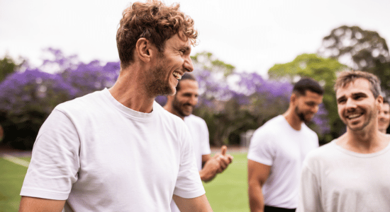 Group of male soccer players walking on sports field together,