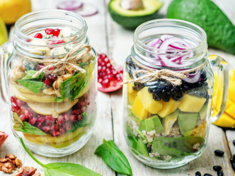 homemade healthy salads with vegetables, fruits, beans and quinoa in jar