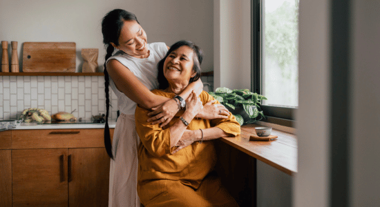 Woman hugging older woman in a kitchen