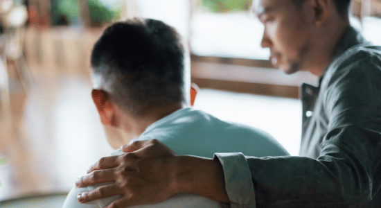 Man comforting someone on a couch