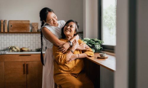 Happy woman hugging her mother in the kitchen