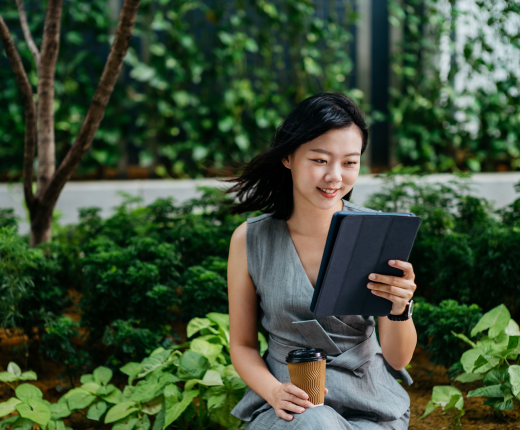 A woman looks at her tablet outside