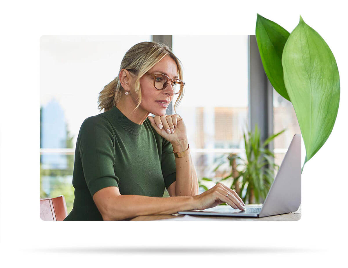 Femme portant des lunettes travaillant sur son ordinateur portable.