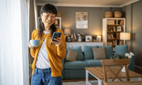 Japanese woman smiling while looking at her phone