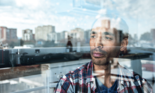 Mature man contemplating while look through window at home
