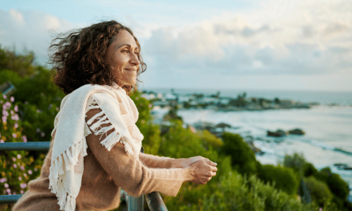 Mature woman smiling looking out at the ocean