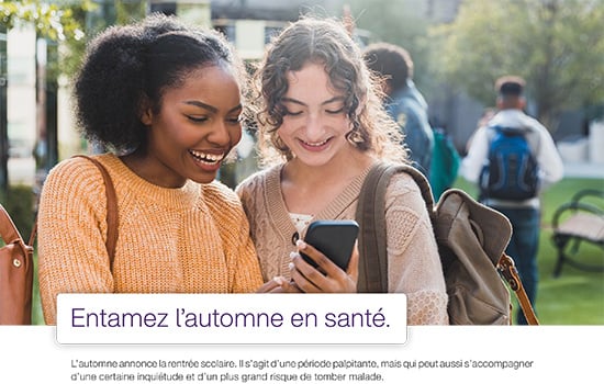 Deux femmes qui regardent un téléphone en souriant - entamez l'automne en santé
